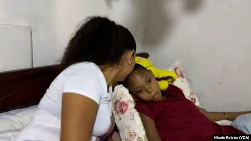 Johana Fernández besa a su hija Yohalis, de 17 años, que se recupera de una crisis de dolor./VOA
