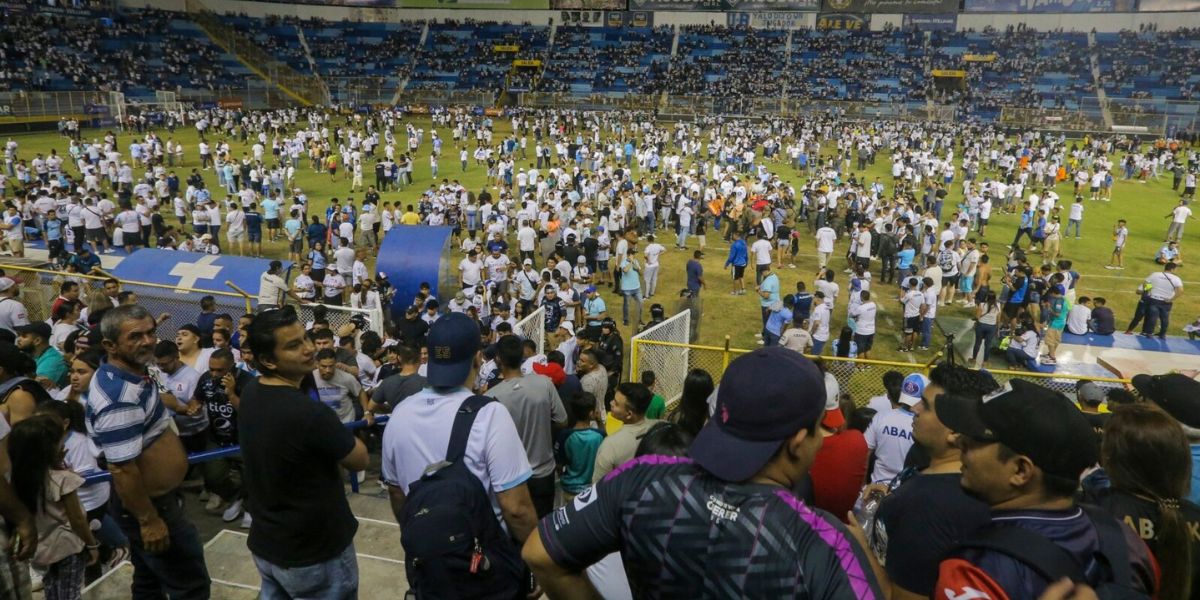  Aficionados irrumpen en el terreno del estadio Cuscatlán en San Salvador, El Salvador, para ayudar a las víctimas de una estampida que dejó 9 muertos y decenas de heridos el 20 de mayo de 2023. Foto: Voz de América.