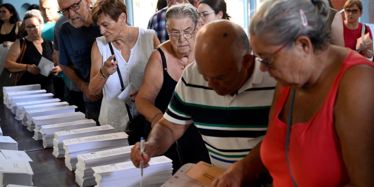 La gente elige sus papeletas en un colegio electoral en Badalona, ​​durante las elecciones generales de España, el 23 de julio de 2023. (Foto de Josep LAGO / AFP)