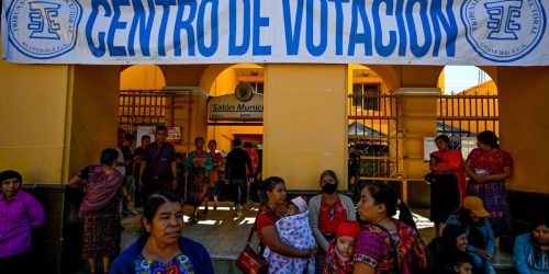 La gente espera afuera de un centro de votación en el municipio de San Juan Sacatepéquez durante la segunda vuelta de las elecciones presidenciales de Guatemala el 20 de agosto de 2023.