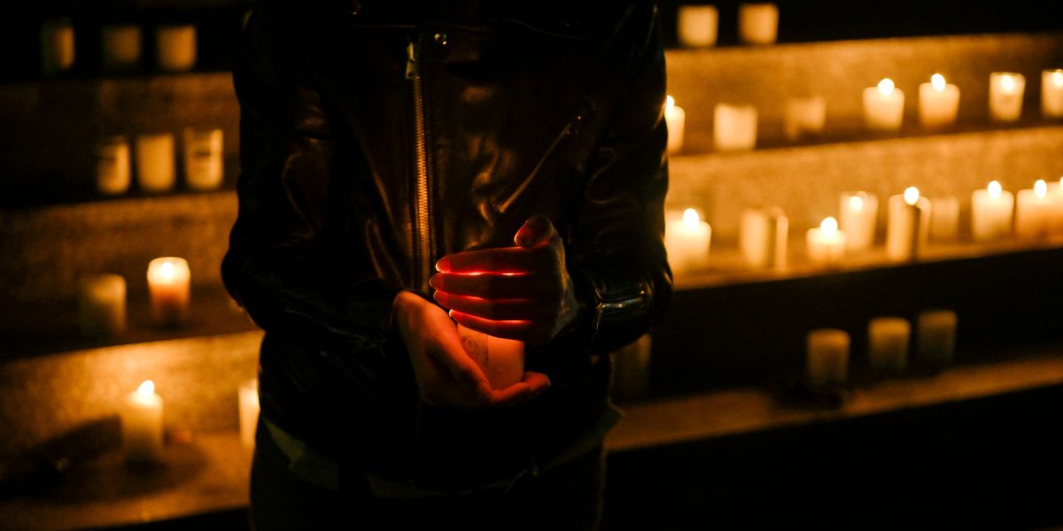  Una mujer sostiene una vela frente al Teatro Nacional de Kosovo para conmemorar el Día Mundial de la Prevención del Suicidio. 10 de septiembre, 2023. Foto: Armend Nimani / AFP.