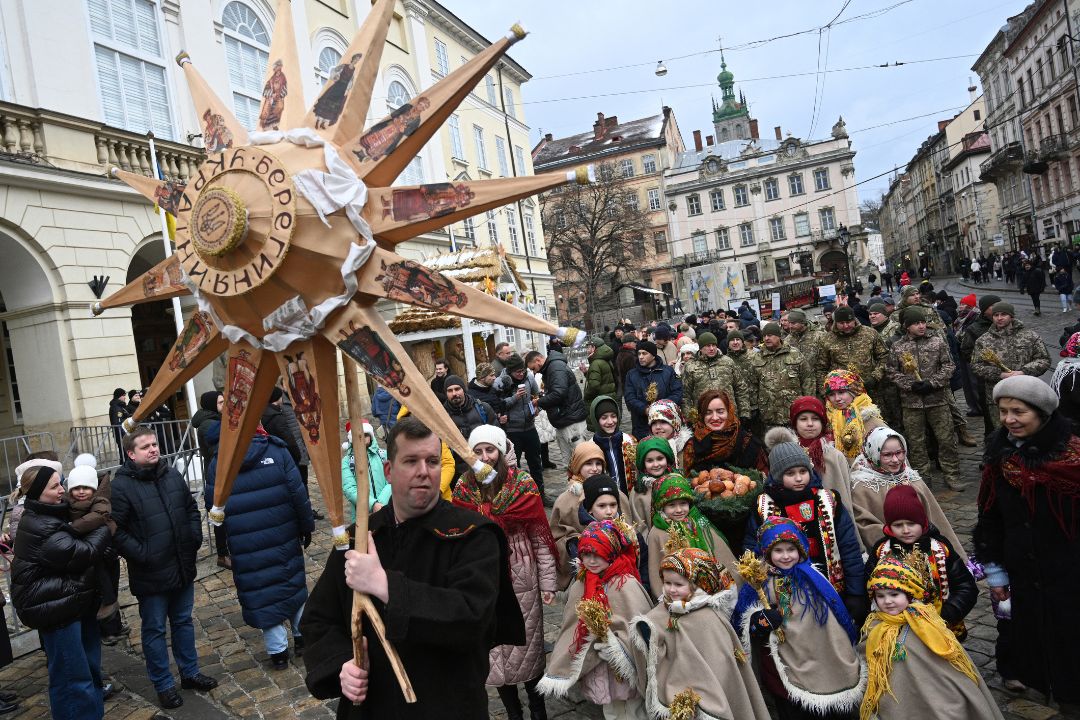 La gente camina por las calles mientras participa en la celebración de Nochebuena en Lviv, el 24 de diciembre de 2023, en medio de la invasión rusa de Ucrania. Foto : AFP / NI.