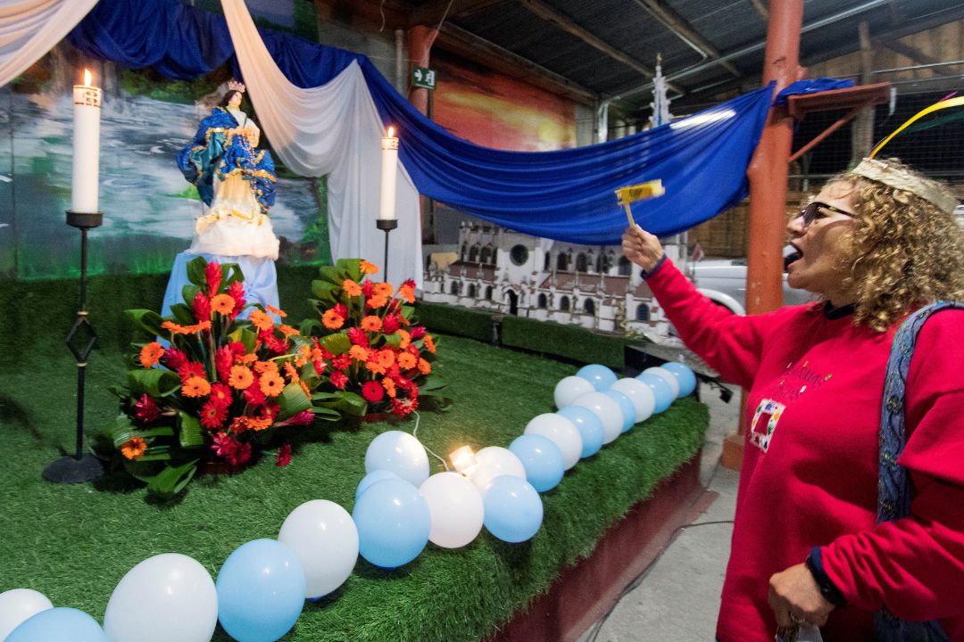 Una mujer canta frente al altar con la imagen de la Virgen María durante la tradicional fiesta católica de “La Gritería” en la parroquia San Isidro Labrador, Vásquez de Coronado en San José. Costa Rica, 7 de diciembre de 2023. Foto: AFP/ NI.