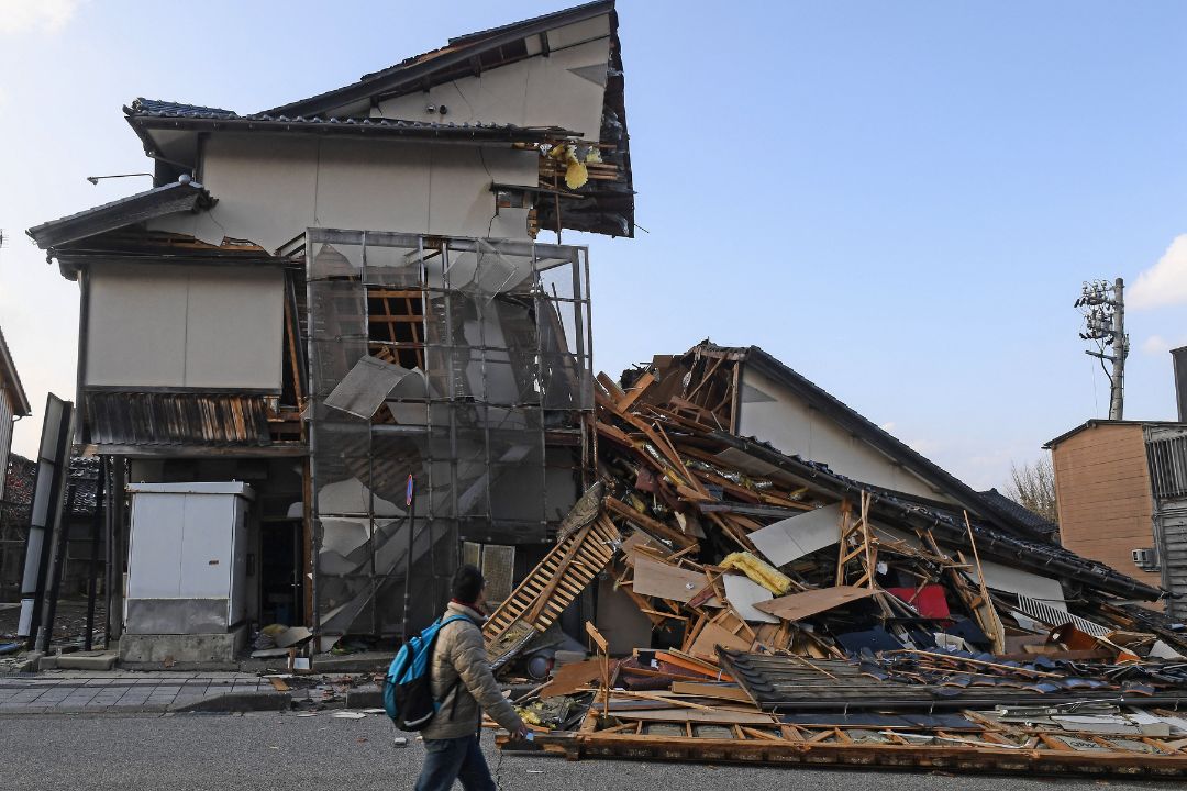 Un hombre pasa junto a edificios derrumbados en Wajima, prefectura de Ishikawa, el 6 de enero de 2024, después de que un gran terremoto de magnitud 7,5 sacudiera la región de Noto el día de Año Nuevo. Foto: Toshifumi Kitamura / AFP.