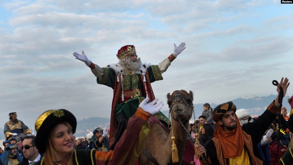 Un hombre vestido como uno de los Tres Reyes saluda a la gente durante el desfile de la Epifanía en Gijón, España. Foto: VOA.
